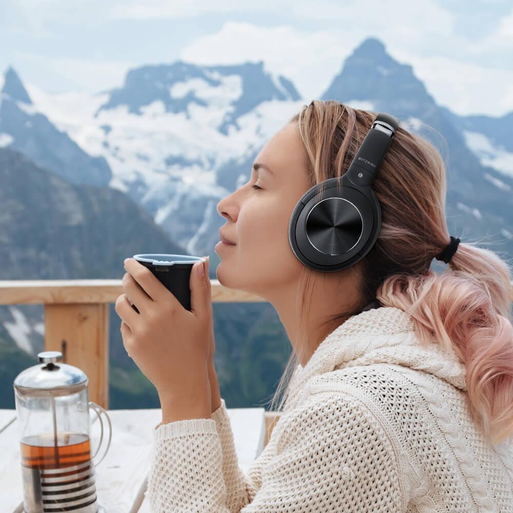 Nő BlitzWolf BW-HP3 fejhallgatót viselve relaxál